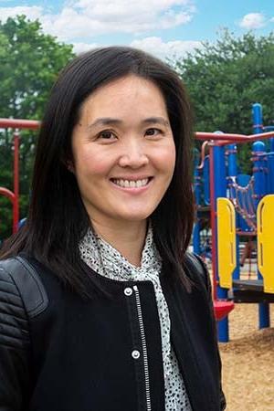 Vivian Song Maritz smiles for a photo while standing in a playground